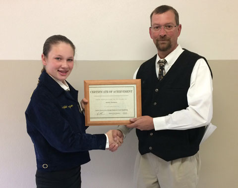Greg Cash presents the first place certificate to Wiley’s Maddie Thompson after competition on Wednesday.